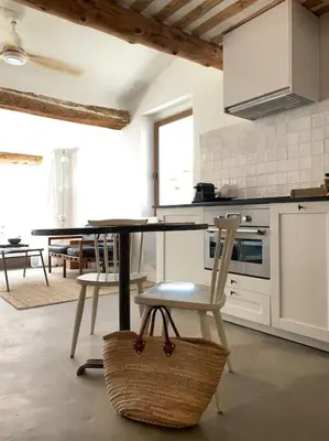 a kitchen with a table and chairs in a room at La terrasse du pont jullian charme et calme dans le cœur historique in LʼIsle-sur-la-Sorgue