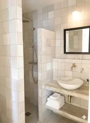 a white bathroom with a sink and a mirror at La terrasse du pont jullian charme et calme dans le cœur historique in LʼIsle-sur-la-Sorgue