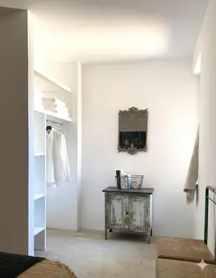 a room with a table and a mirror on a wall at La terrasse du pont jullian charme et calme dans le cœur historique in LʼIsle-sur-la-Sorgue