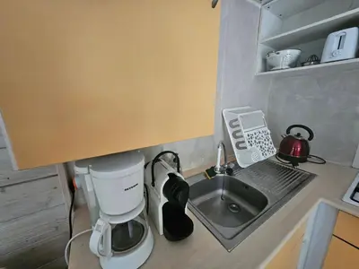 a tiny kitchen with a sink and a coffee maker at TOSCANE in Saint-Rémy-de-Provence
