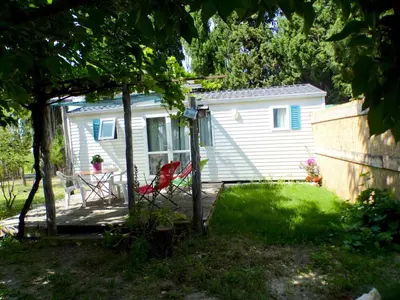 a small white house with a table and chairs in a yard at TOSCANE in Saint-Rémy-de-Provence