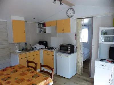a kitchen with yellow cabinets and a table and a clock at TOSCANE in Saint-Rémy-de-Provence