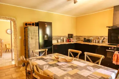 a kitchen with a table with chairs and a kitchen with a counter at Village house of Jean in Gordes