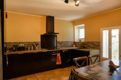 a kitchen with a stove top oven next to a table at Village house of Jean in Gordes