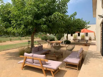 a patio with chairs and a table and a tree at Contemporary house 5mn away from Aix in the countryside in Aix-en-Provence