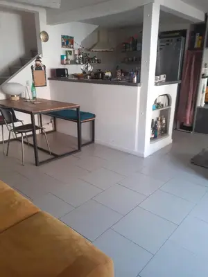 a living room with a table and a kitchen at Aude en Provence in Meyrargues