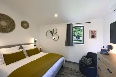 a bedroom with a large bed and a window at Les Agapanthes de Gordes in Gordes