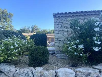 a garden with white flowers and a stone wall at Les Agapanthes de Gordes in Gordes