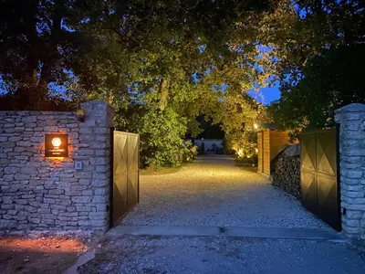 an entrance to a driveway with a gate with a light on it at Les Agapanthes de Gordes in Gordes