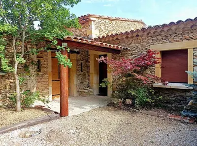 a brick house with a red door and a garage at Maison à Gordes dans le Lubéron in Gordes