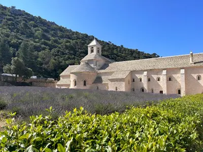 an old church on a hill with a field of flowers at Maison à Gordes dans le Lubéron in Gordes