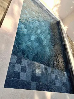 a swimming pool with a mosaic floor in a room at Maison à Gordes dans le Lubéron in Gordes