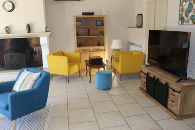 a living room with yellow chairs and a flat screen tv at Mas La Gentille ,,, à la campagne , beautiful outdoor , swimming pool , pool house , Nice green Garden , BBQ ,,, only for you , pour passer un séjour inoubliable in Pernes-les-Fontaines