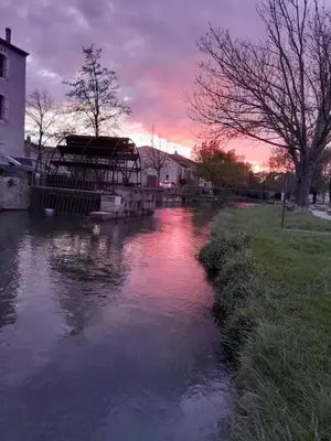 a river with a boat in it at sunset at Casa Mia, chambre privée en Provence in LʼIsle-sur-la-Sorgue