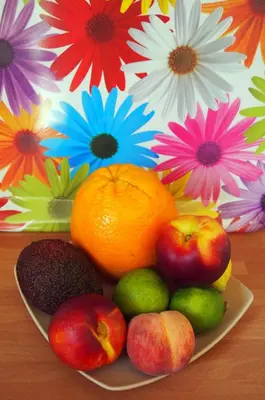 a plate of fruit on a table with flowers at L'Islo Bamboo in Saumane-de-Vaucluse