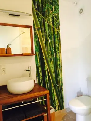 a bathroom with a sink and a bamboo shower curtain at L'Islo Bamboo in Saumane-de-Vaucluse