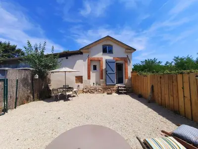 a house with a fence and a table and an umbrella at adorable guest house avec jardin et parking privatif in Aix-en-Provence