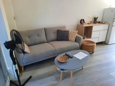 a living room with a couch and a table at adorable guest house avec jardin et parking privatif in Aix-en-Provence