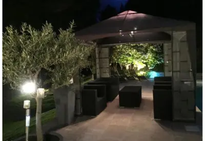 a pavilion with trees and a building at night at Chambres d'hôtes La Manola in Rognes