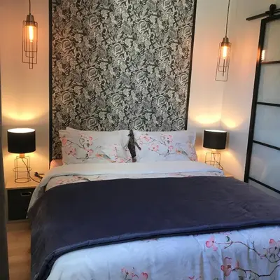 a bedroom with a bed with a black and white patterned wall at Chambres d'hôtes La Manola in Rognes