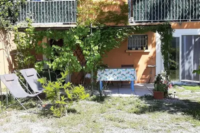 a table and two chairs sitting in a yard at T.Belle Vue Panoramique au coeur du Luberon 40m2 + pergola . jardin. P in Apt