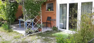 a house with a window and a table and a chair at T.Belle Vue Panoramique au coeur du Luberon 40m2 + pergola . jardin. P in Apt