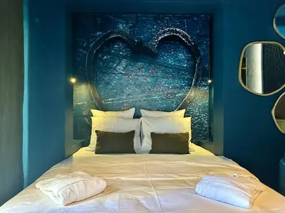 a bedroom with a bed with a large headboard at LOVE IN L'ISLE/SORGUE Le crépuscule in LʼIsle-sur-la-Sorgue