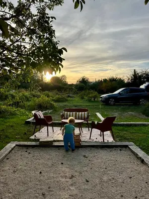 a little child standing next to a table and chairs at Le Cabanon de Léandre in Meyrargues