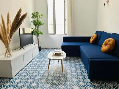 a living room with a blue couch and a tv at L'Aixalté - T2, Vieille Ville in Aix-en-Provence