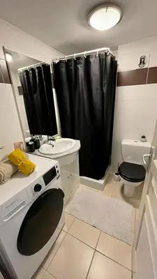 a bathroom with a black shower curtain and a toilet at ADDIS 2 in Salon-de-Provence