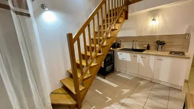 a kitchen with a wooden staircase in a room at ADDIS 2 in Salon-de-Provence