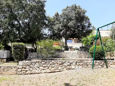 a stone wall and a swing in a park at Villa charmante à Mérindol avec piscine privée in Mérindol