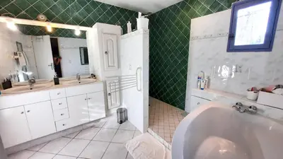 a bathroom with a tub and two sinks and a mirror at Villa charmante à Mérindol avec piscine privée in Mérindol