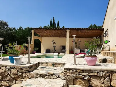 a swimming pool in a yard with potted plants at Villa charmante à Mérindol avec piscine privée in Mérindol