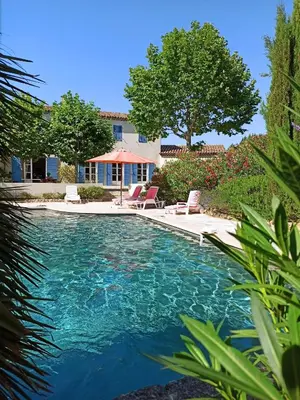 a swimming pool with two chairs in a yard at La bastide de Cocagne in Rognes