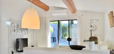 a living room with a large window and a television at maison bertuli Oliviers Aircon, heated saltwater Pool, 2 Bedrooms in Oppède