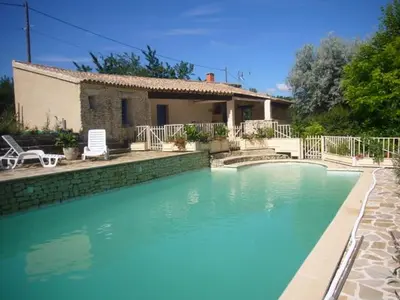 a large swimming pool in front of a house at Goult (LUBERON) A 150 m de la piste cyclable Maison en campagne avec Gde piscine in Goult