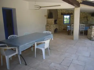 a dining room with a table and chairs and a fireplace at Goult (LUBERON) A 150 m de la piste cyclable Maison en campagne avec Gde piscine in Goult