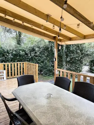 a garden with pink flowers and a wooden house at Mobilhome 228 proche du Lac , Tv , clim ect Camping in La Roque-dʼAnthéron