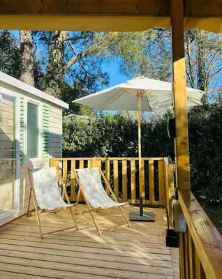 a living room with a table and a couch at Mobilhome 228 proche du Lac , Tv , clim ect Camping in La Roque-dʼAnthéron