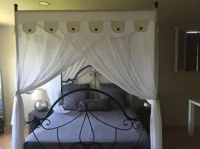 a bedroom with a black bed with a canopy at villa entre st rémy de provence et avignon in Noves