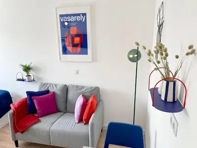 a living room with a gray couch with colorful pillows at Ma place au sud 1.08 in Éguilles