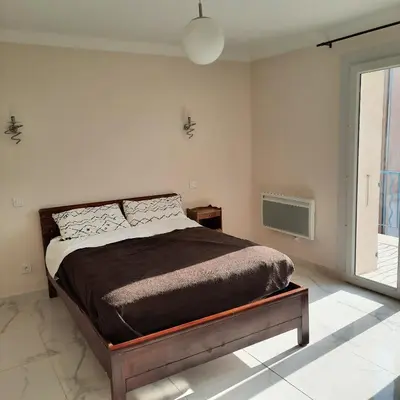 a bedroom with a bed and a large window at Maison provençale rénovée in Pernes-les-Fontaines