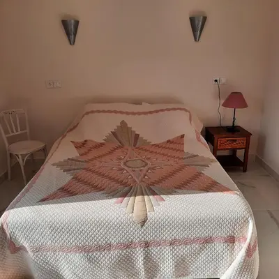 a bedroom with a bed with a comforter on it at Maison provençale rénovée in Pernes-les-Fontaines