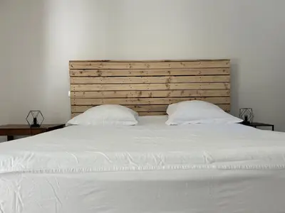 a large white bed with two pillows on it at Le Pavillon de Nina in Puget
