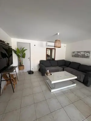 a living room with a couch and a table at Le Pavillon de Nina in Puget