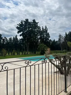 a wrought iron gate with a pool in a park at LE MAS MILA in Monteux