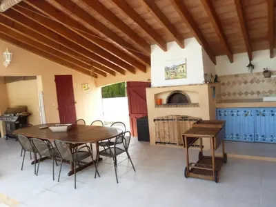 a dining room with a wooden table and chairs at Magnifique villa au calme avec piscine, sauna et jacuzzi in Pélissanne