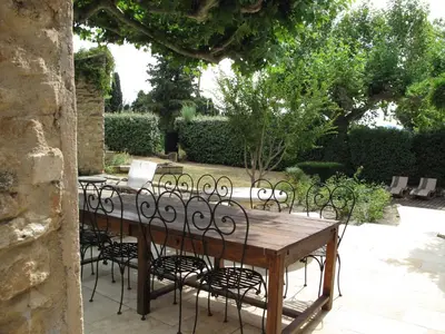 a wooden table with black chairs around it at Mirabelle en Provence in Eygalières