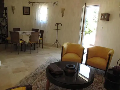 a living room with a table and chairs at Mirabelle en Provence in Eygalières